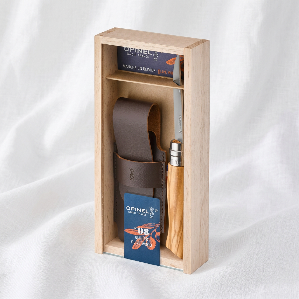 Navaja personalizada con funda de cuero y caja de madera sobre tela blanca